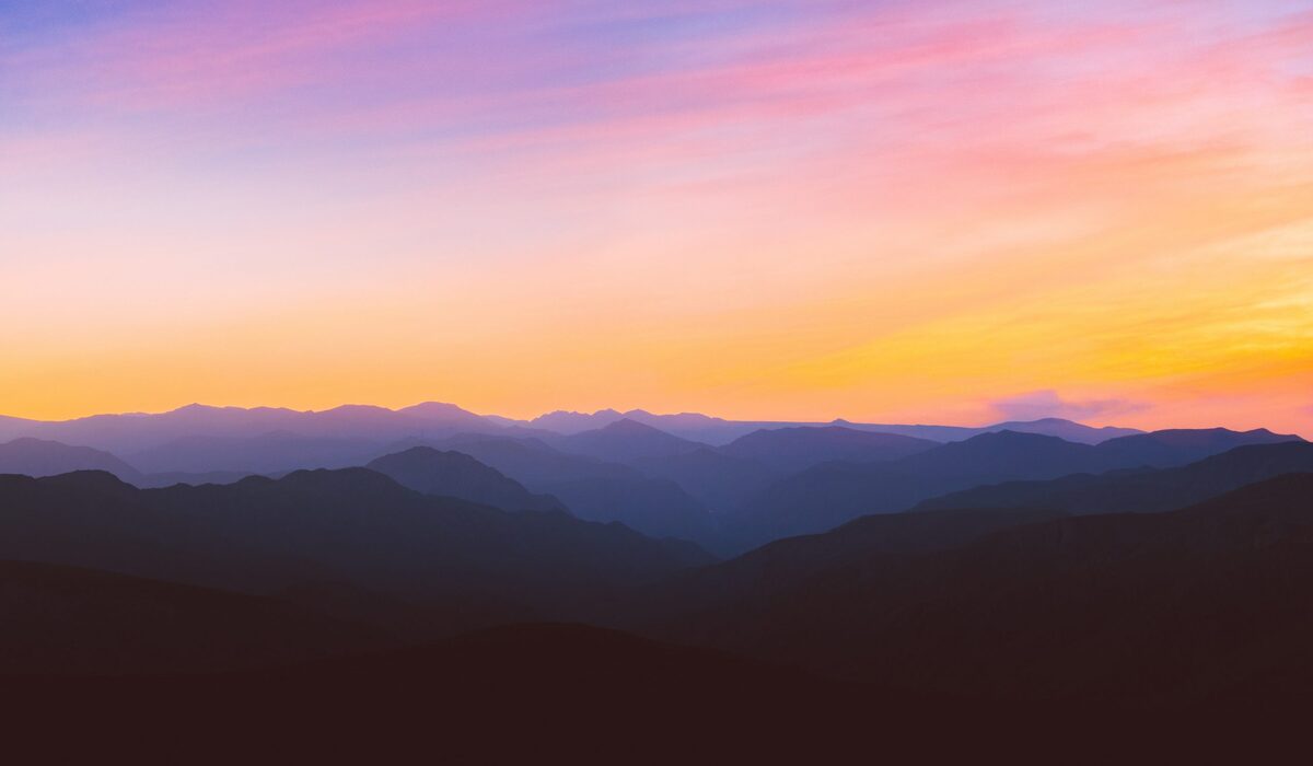 Orange and purple sky over a mountain range