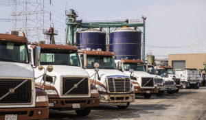 Lineup of Baker Trucks with Silos in background