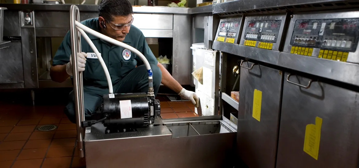 A Baker Commodities technician handles used cooking oil pickup from a restaurant.